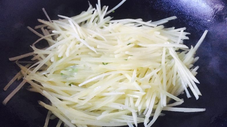 #圆土豆# 花椒油青椒土豆丝,迅速翻炒均匀,并且不断翻炒。