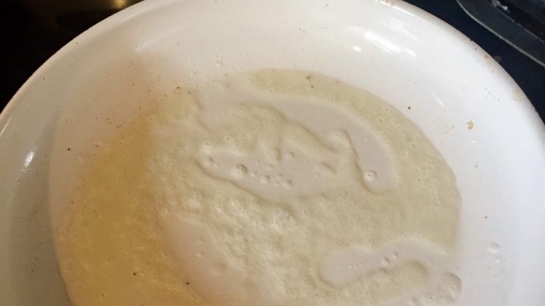 地道的美式早餐之———香煎土豆丝饼,黄油融化后把平底锅晃动一下,用锅铲帮助黄油均匀地涂抹在锅里。