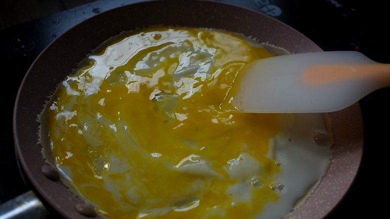 杂粮卷饼,用铲子将鸡蛋打散,摊平