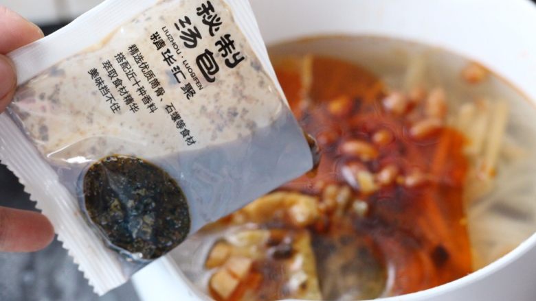 壶城人家螺蛳粉,将煮好的米粉,捞至另外一个盆中备用。把煮米粉的水倒掉,重新加入水,把剩下的配料包放入奶锅里煮透。