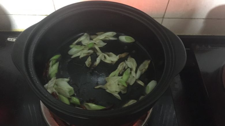 黑乐砂锅之炝锅莲藕块,黑乐砂锅中倒入适量的油烧热后，放入葱段、花椒、干红辣椒炝炒出香味。