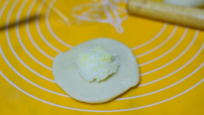 椰蓉小面包,将每个小面团擀成小圆饼,把椰蓉馅儿放入中间
