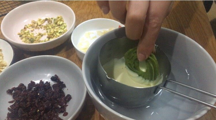 圣诞花环版抹茶曲奇,白巧克力融化,把饼干放入巧克力蘸一下;