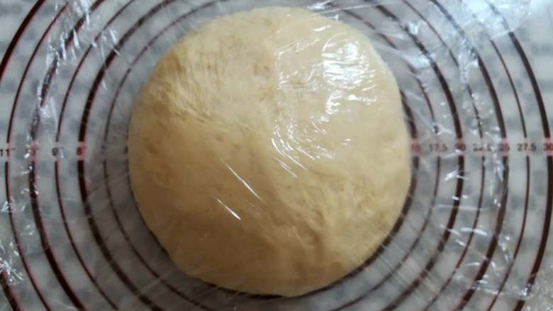 红豆面包(面包机版),把面团取出来挤掉大的气泡,滚圆用保鲜膜盖上松弛15分钟