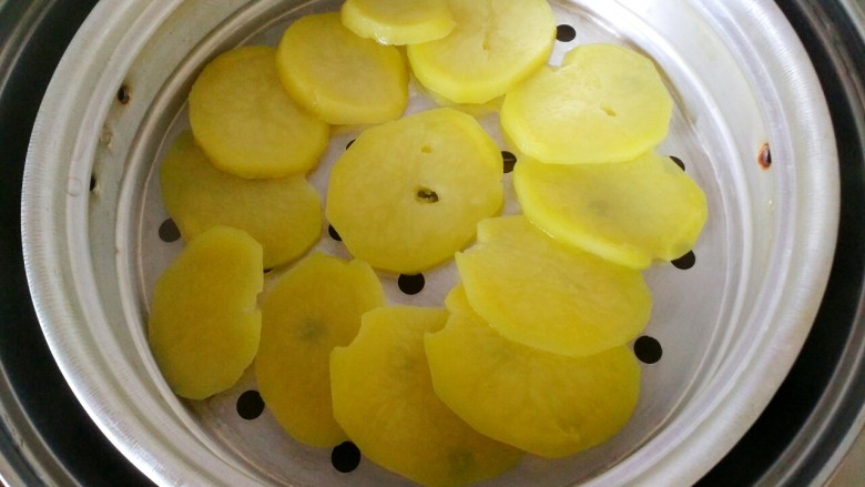 #圆土豆#黑芝麻土豆球,蒸熟的土豆片，用筷子能扎透就可以熟了