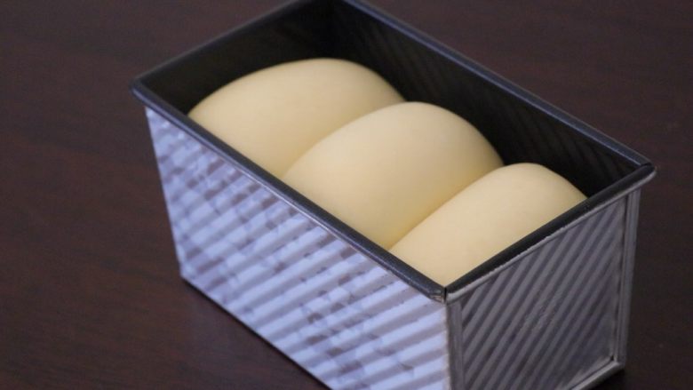 炼乳吐司,发至八分满,即可取出来,180度预热烤箱。然后加盖放入预热好的烤箱中下层,上下火170度40分钟