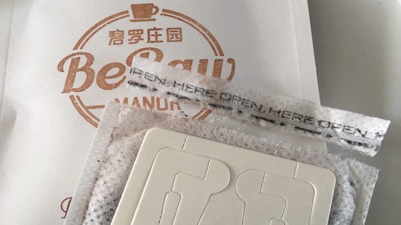奶萃挂耳咖啡,撕开奶萃挂耳咖啡外袋,取出挂耳包,并沿虚线撕开挂耳咖啡。