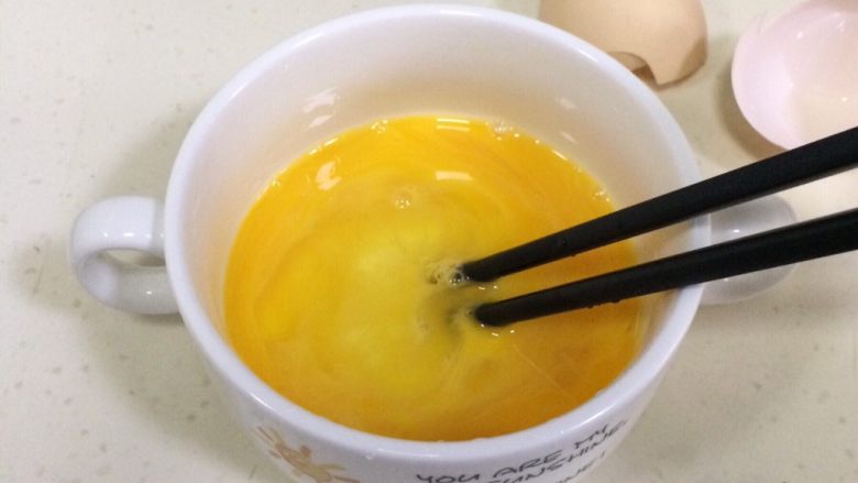 磷虾蒸蛋羹,用筷子搅打鸡蛋,打出气泡,打的越散越好,然后用汤匙滤掉表面的浮泡。