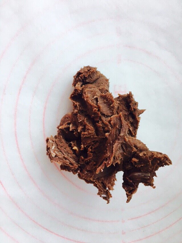 网红脏脏包(开酥版),将搅拌好的巧克力黄油,摊平在一张油纸上。