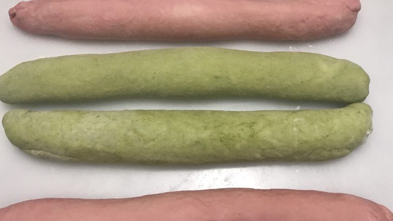 圣诞风双色奶酪吐司,分别卷起,捏紧收口,案板撒薄粉,略搓长,比吐司盒长一些。