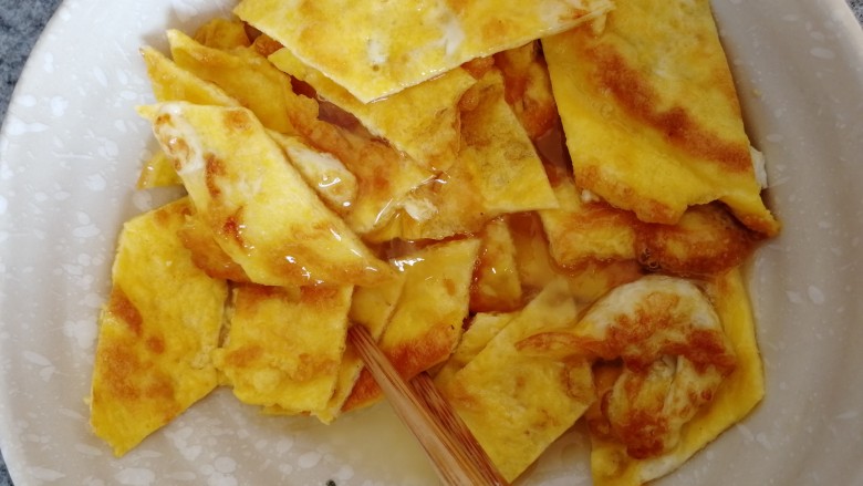 酥黄菜,放进鸡蛋清的碗里粘一下,把煎好的鸡蛋包裹均匀。