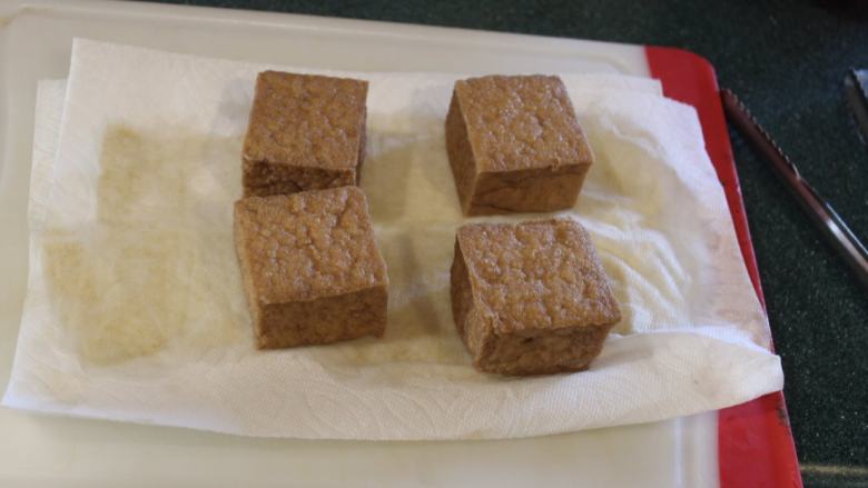 猪肉油豆腐烧,捞出油豆腐,用纸巾吸掉表面油汁和水分。