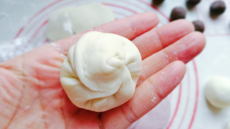 花式豆沙包,然后四周捏皱折包起来,收口处捏紧稍整理下再搓圆;