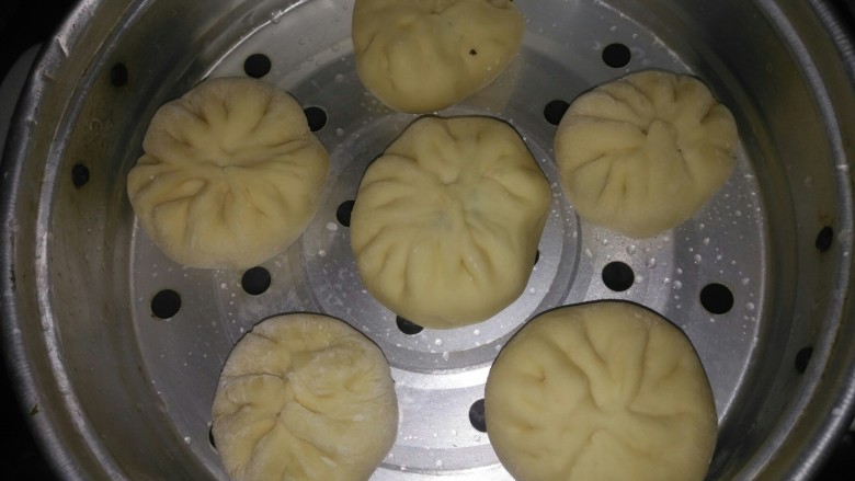 火腿肠肉包子,准备一点干粉搓手防止粘手,开始包啦(想皮薄均匀用擀面杖擀面皮),包漂亮包子的方法你需要去找腾讯视频里面有技巧,让你包得漂漂亮亮的哦,蒸架抹点油,然后包子放下去先放置一会让它再发一下,电饭锅锅里烧至温水,包子放进去蒸12-14分钟