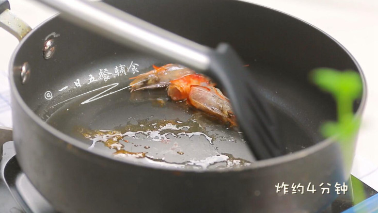鸡蛋豆腐鲜虾羹,倒入稍微多一点油,中小火炸虾头。炸的时候用铲子压一压虾头。