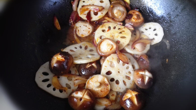 鸡肉麻辣香锅,倒入藕片和香菇翻炒,