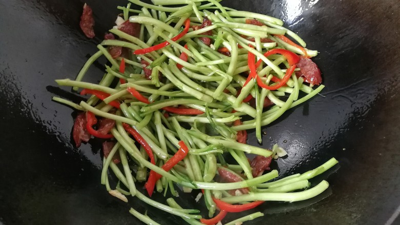 腊肠炒泥蒿,再调入少许盐,继续翻炒一下;