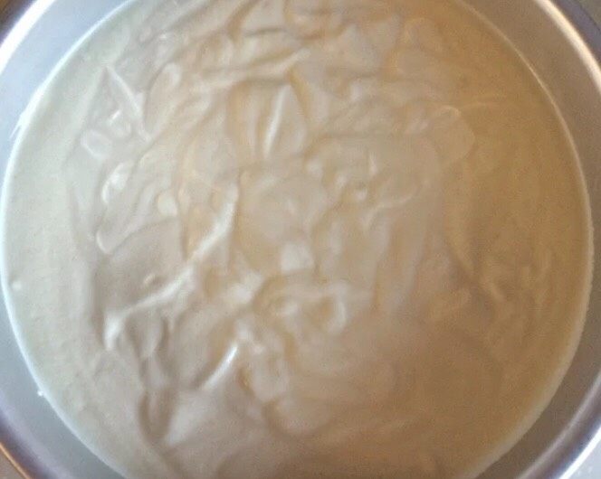 零失败八寸戚风蛋糕,将搅拌好的面糊从高处倒入模具中,然后再震几下模具,使面糊平整。