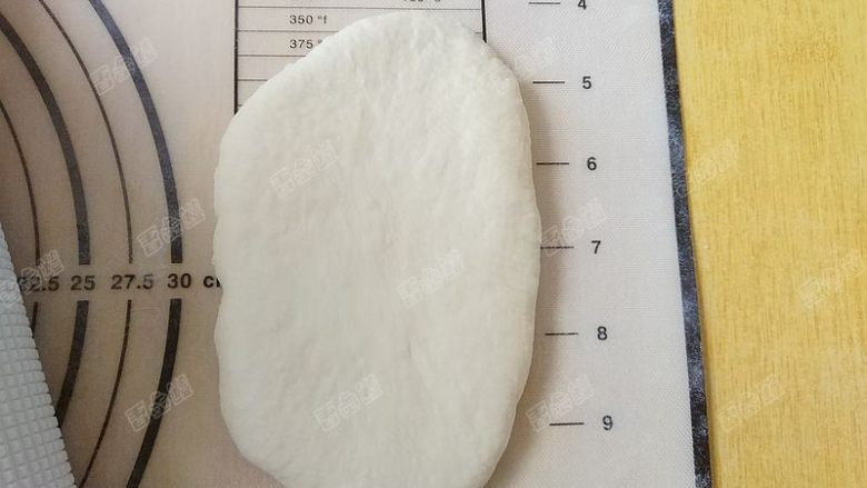 水立方蜂蜜小吐司,取一个松弛好的面团,椭成牛舌状
