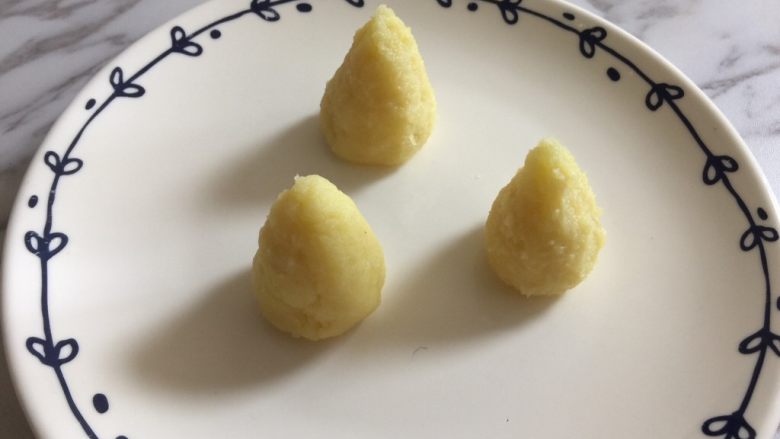 圆土豆+可可麦片土豆泥松塔,把土豆泥平均分成3份,揉圆后,捏成锥形。