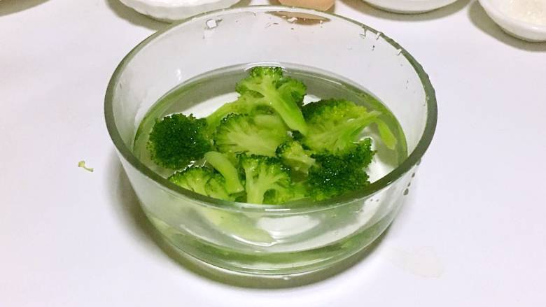 鳕鱼蔬菜米饼,焯好的西兰花捞出,放入冷水中冷却一下。
PS: 焯水后的蔬菜温度比较高,离水后与空气中的氧气接触容易产生热氧作用,营养素会流失。所以需要及时冷却降温,减少营养流失,还可以保持蔬菜翠绿的颜色。