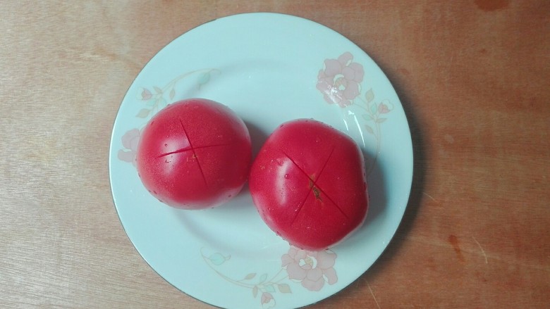 馋了~来碗番茄巴沙鱼汤,两根<a style='color:red;display:inline-block;' href='/shicai/ 59'>番茄</a>洗净,用刀在顶部划十字