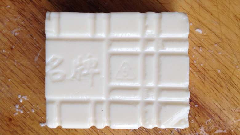 豆腐饺子,然后把上面的封口膜撕去,倒扣在案板上,再用刀修整成正方形