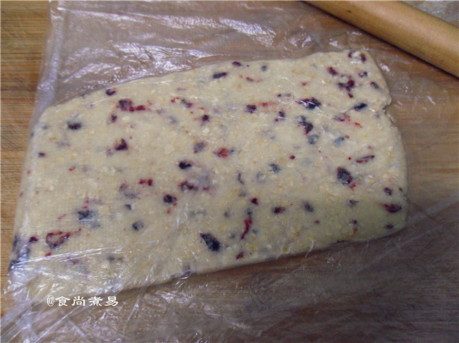 蔓越莓手指饼干,从冰箱取出面团,用擀面杖顺着保鲜袋均匀擀开成为一块方饼