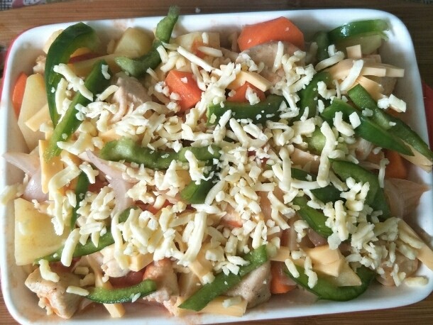 西红柿鸡肉焗饭,再铺上青椒丝,撒一层芝士,放入预热好的烤箱200度烤15分钟