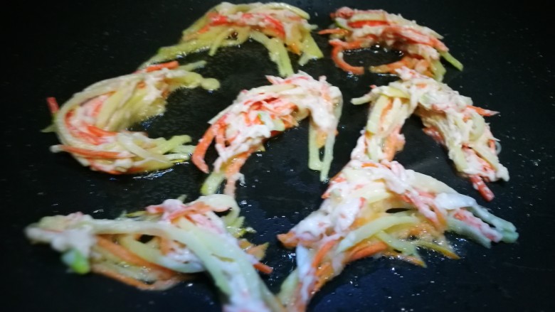 圆土豆~炸假虾,锅中倒油 将土豆胡萝卜丝用筷子夹入锅中