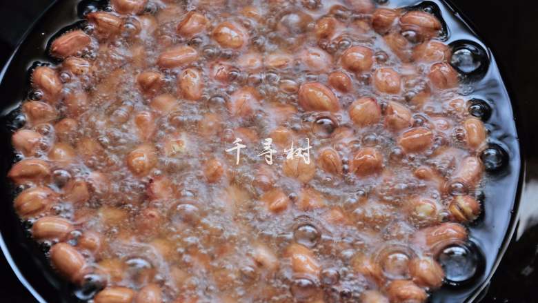 香酥油炸花生米,炸的过程中要用漏勺或是锅铲一直轻轻推动花生米,因为花生米比较沉,贴着锅底的部分容易过热,不停推动可以让花生米整体受热均匀。温度慢慢上升后,花生米周围的气泡也越来越多,因为花生米中的水汽都被蒸发了出来。 花生米在锅里噼里啪啦的响。