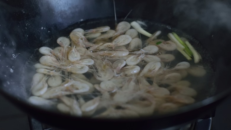 美极油淋虾,倒入白虾,焯至水再次沸腾。捞起沥干,倒在香菜上。