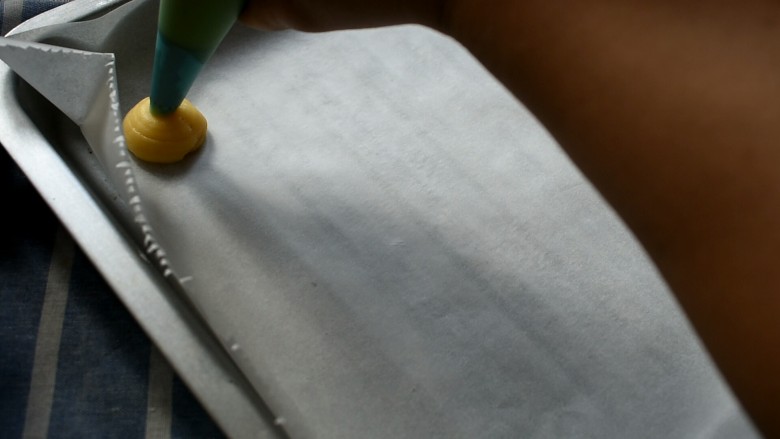 玩偶泡芙,将面糊装入裱花袋，挤在硅油纸上边