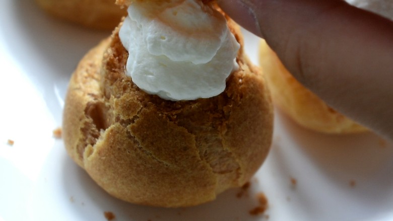 玩偶泡芙,再将剪下来的盖子盖在奶油上，像小帽子一样