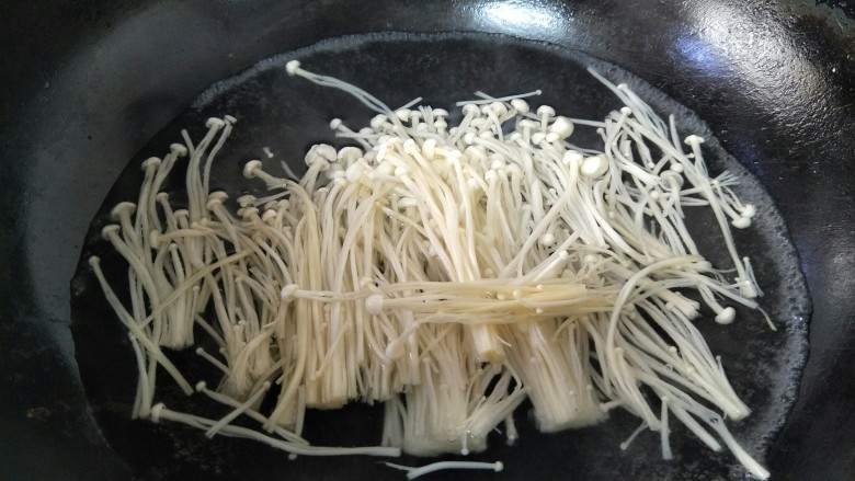 家常酸汤肥牛,金针菇洗净切去根部,焯水,捞出备用。