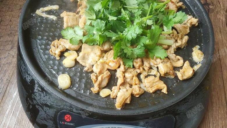 烧饼夹烤肉,接着关火并加入香菜。继续翻炒均匀,余温会使香菜变熟。将烤肉盛盘。