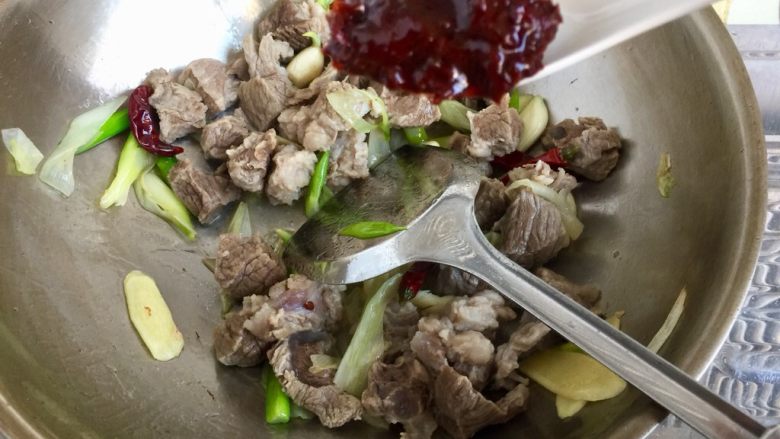 山药胡萝卜牛肉煲,加入一勺豆瓣酱,翻炒均匀