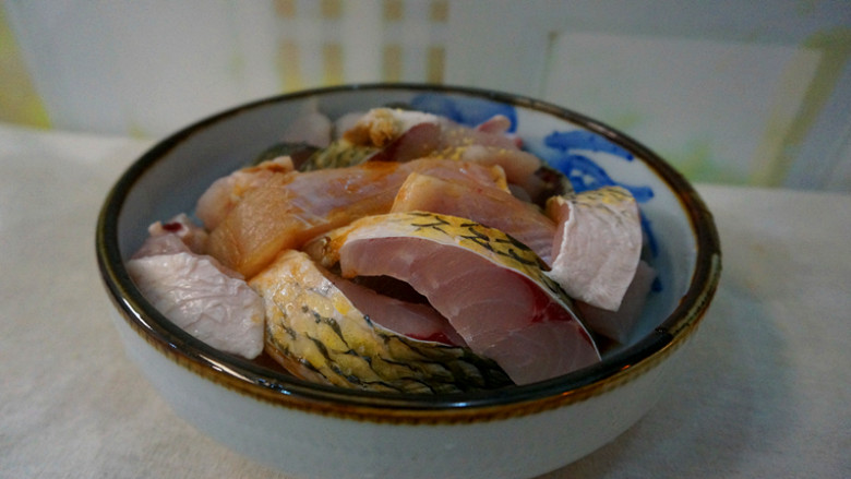 啤酒焖酥鱼,将鱼肉放入一个大碗中:加入少许盐,鸡粉,生抽,料酒