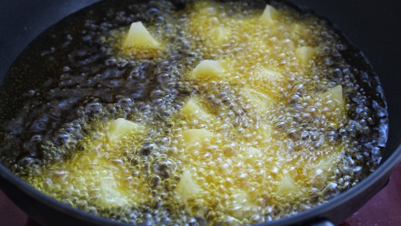 土豆烧茄子,另起锅倒入适量食用油烧至八成热,将土豆放入锅中改中小火炸制