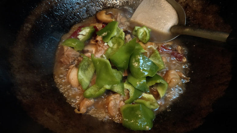 黄焖鸡--肉嫩汁浓拌米饭,这时汤汁会变得浓稠,但不要收干汤汁,放入青椒翻炒断生。