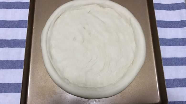 火腿虾仁披萨,然后把面饼卷在擀面杖上帮助挪到烤盘里,用手把中间部分压平整形,放在一旁静置10-20分钟,等待二次发酵