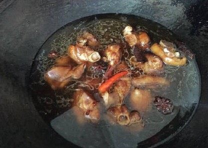 家常菜焖猪脚,此时的猪脚已经明显上色了,马上加入一定的水,要没过猪脚为宜,大火烧开