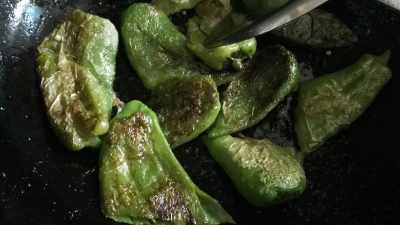 猪油渣炒辣椒豆豉,用铲子把辣椒撮成两节(也可以整个)。