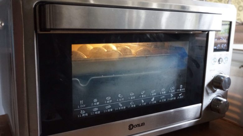 黑豆红枣豆浆小餐包,将面包坯放在东菱K40C烤箱里,烤箱内放置一碗热水,使烤箱内保持一定的湿度,选择烤箱的发酵档,34度发酵40-50分钟
