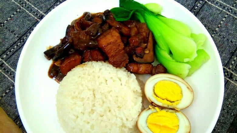 卤肉饭,盛一碗米饭倒扣盘中，卤蛋切开，把卤肉浇到盘中，配以油菜，卤肉饭就做好了。来吃吧！香而不腻！