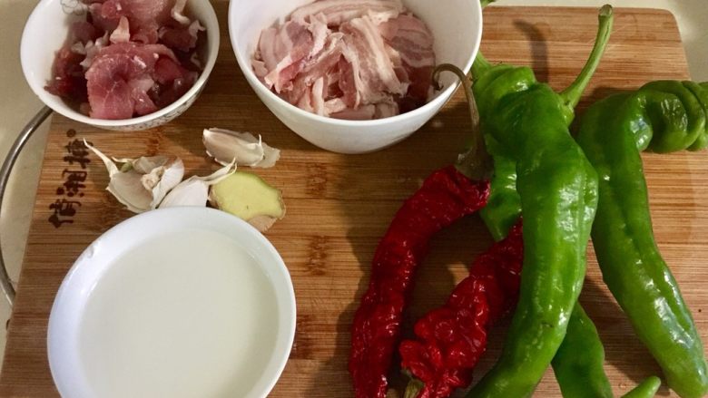 似是小炒肉的尖椒炒肉,尖椒四颗(又加了一颗),红椒两颗,姜一小块,蒜瓣四粒,后腿肉片中加入少许水淀粉拌匀后再加入少许食用油拌匀,以保持炒制后嫩嫩哒