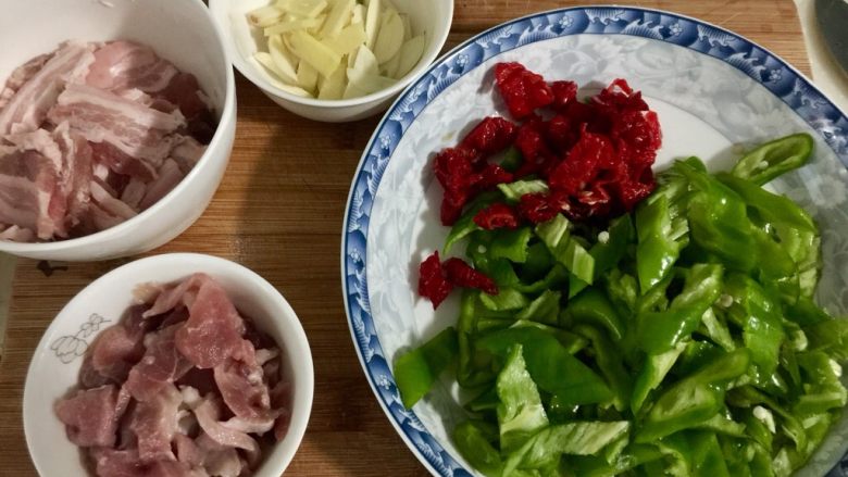 似是小炒肉的尖椒炒肉,红椒尖椒分别切菱形片,姜蒜切片,备用