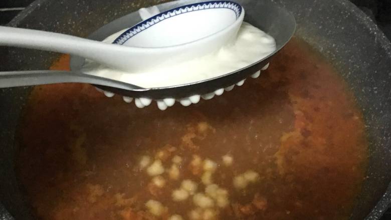 番茄鸡蛋疙瘩汤,水煮开后,面糊倒入漏勺中,用勺子往下压,面糊就从洞里往下滑到锅里了。小火煮约3分钟,面疙瘩浮起来就可以了。