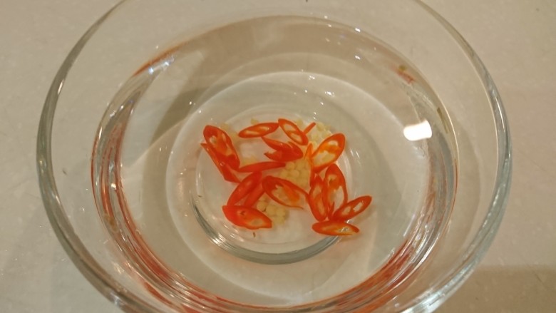 芹時明月,準備一碗水,放入切成圈的紅辣椒,泡一下,撈起辣椒圈備用,籽不要。