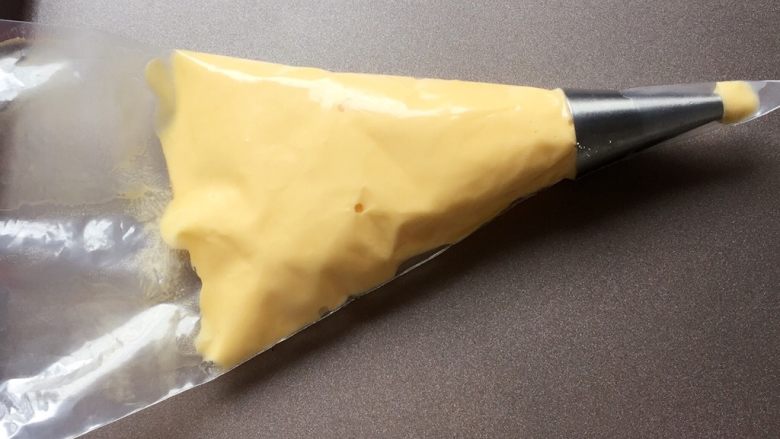百变鸡蛋+蛋黄溶豆,将拌好的蛋黄糊,装入裱花袋中。